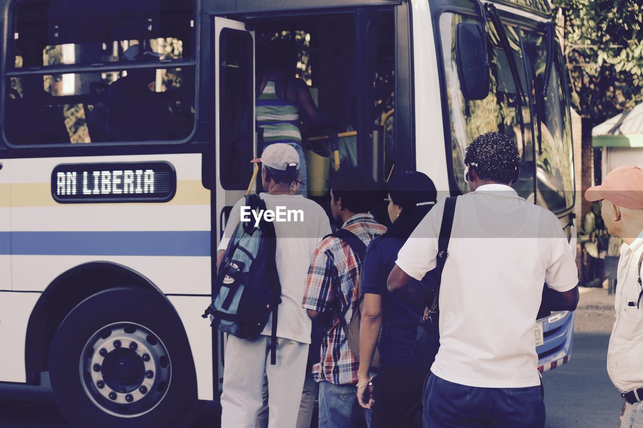 Rear view of people entering into bus