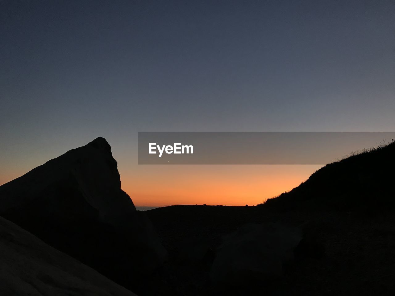 Scenic view of silhouette mountains against sky at sunset