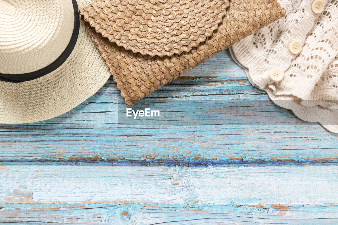 wood, hat, fashion accessory, straw hat, clothing, no people, textile, still life, high angle view, indoors, pattern, blue, close-up, sun hat, table, textured, backgrounds, cap