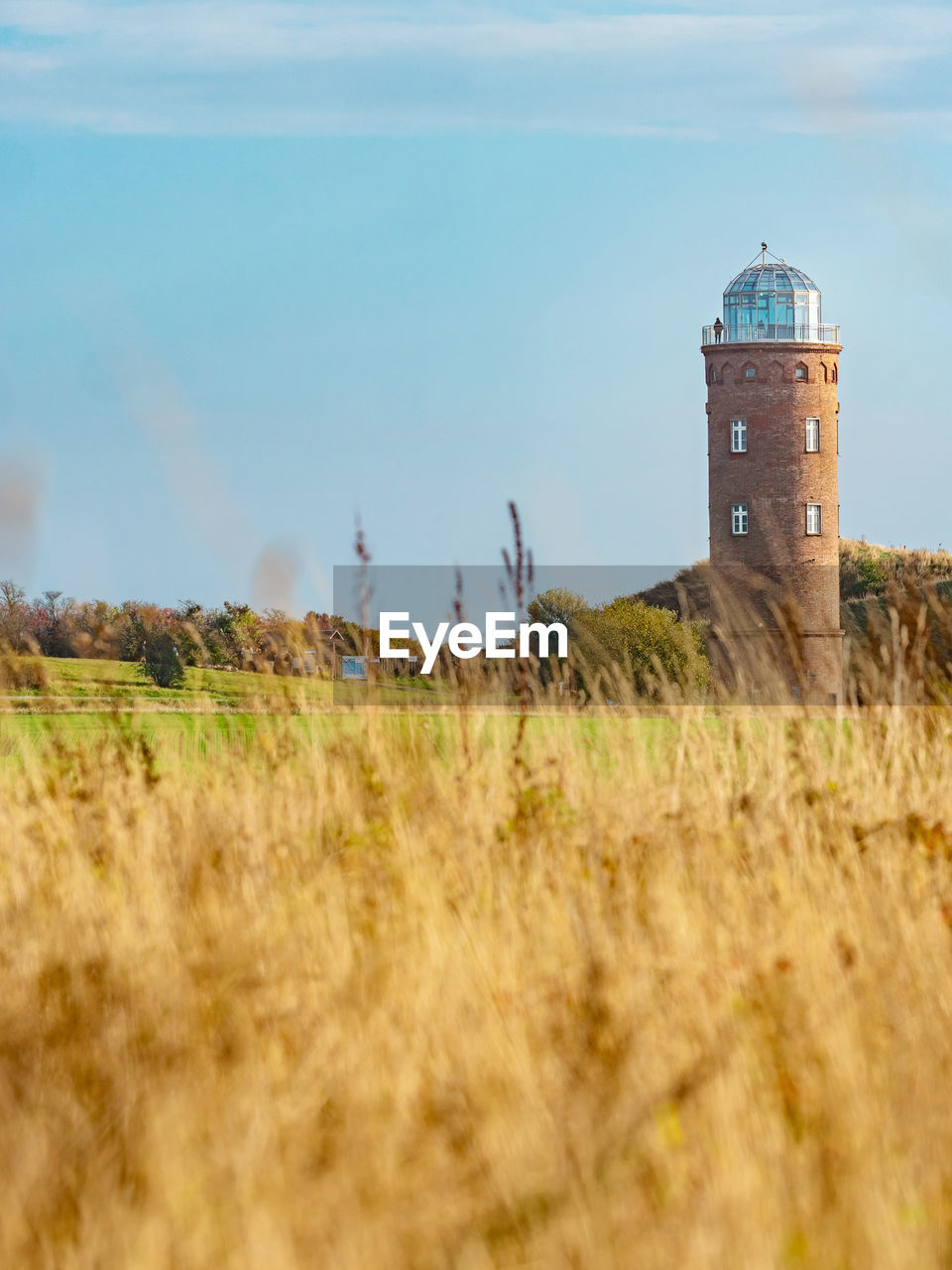 lighthouse, tower, architecture, built structure, building exterior, sky, coast, nature, rural area, guidance, land, plant, building, grass, sea, prairie, landscape, field, no people, history, security, environment, day, agriculture, cloud, hill, outdoors, the past, protection, rural scene, travel destinations, scenics - nature, water, grassland, horizon, travel