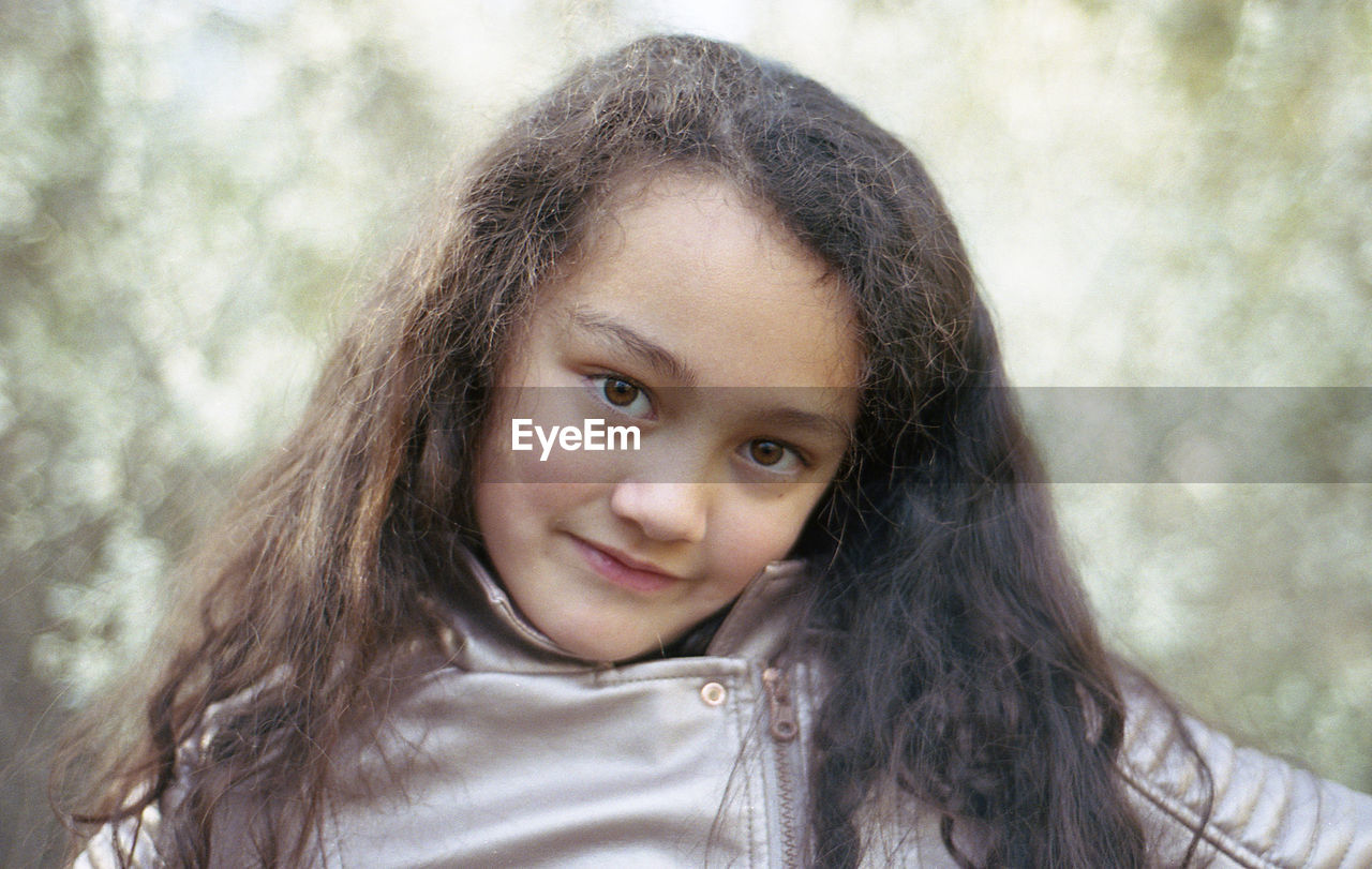 Portrait of smiling girl against trees