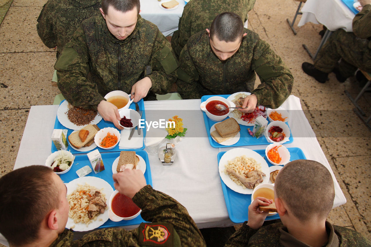 HIGH ANGLE VIEW OF PEOPLE HAVING FOOD IN RESTAURANT