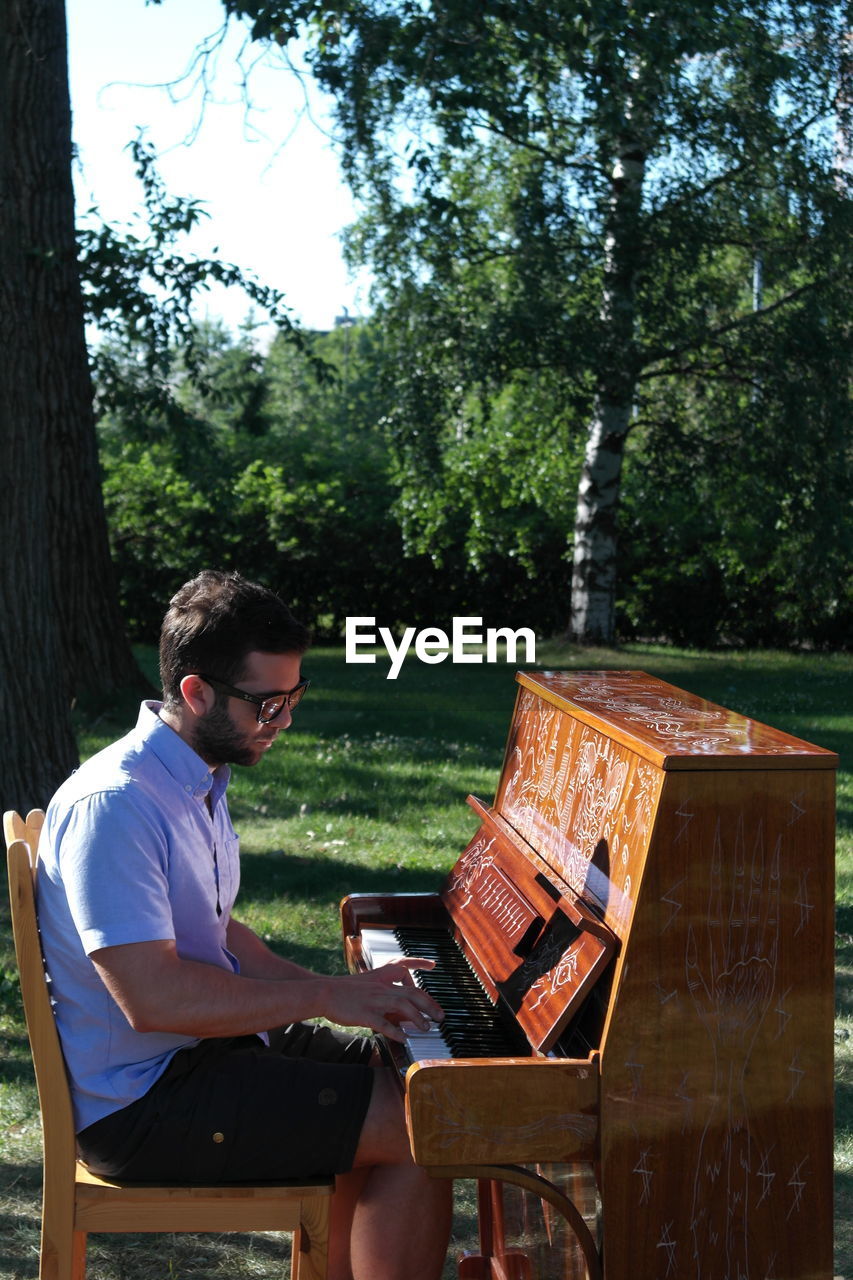 Man playing piano in garden