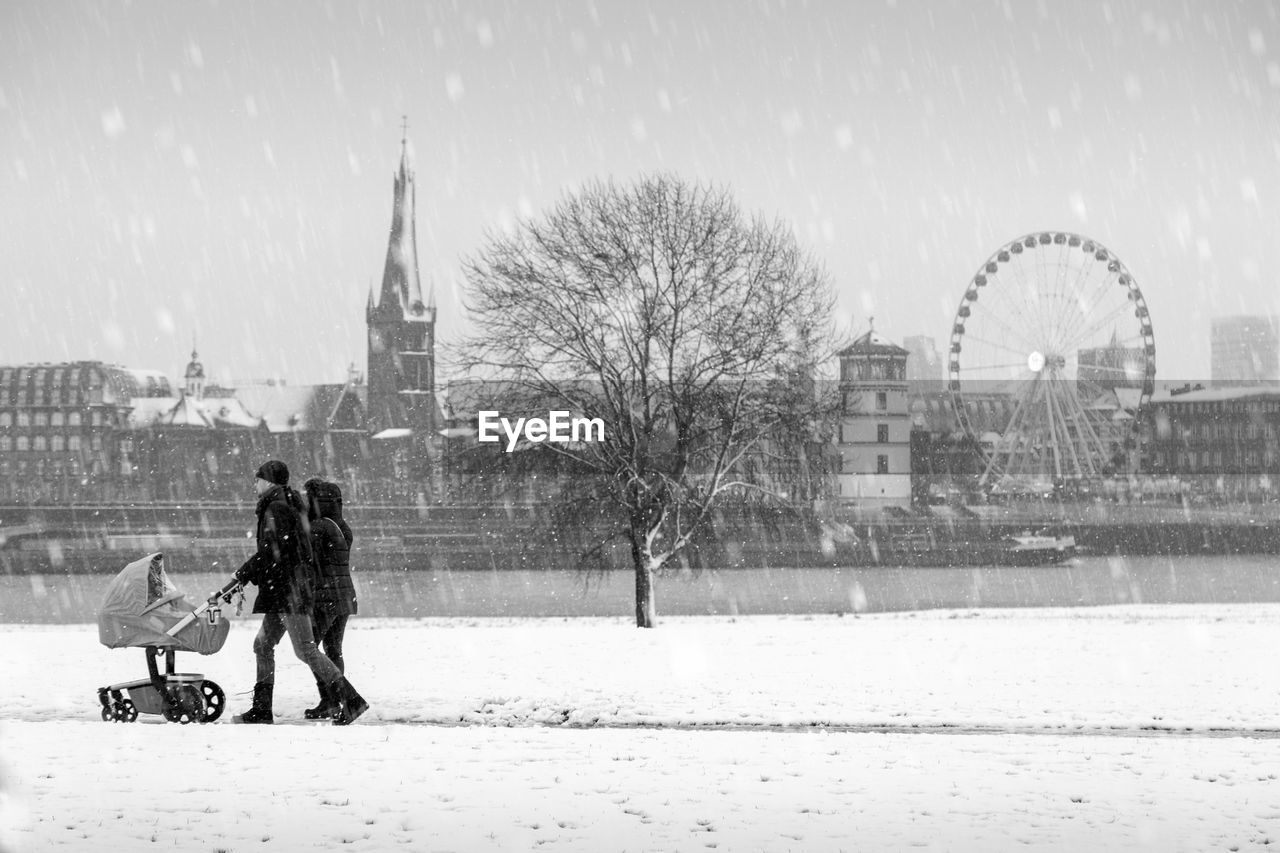 MAN WITH UMBRELLA ON SNOW COVERED CITY