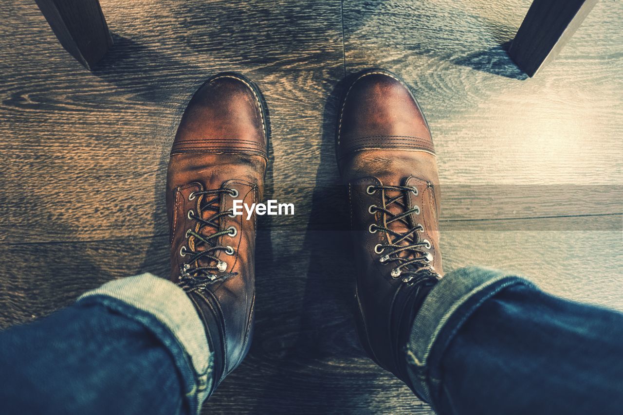 LOW SECTION OF MAN WEARING LEATHER SHOES IN CORRIDOR