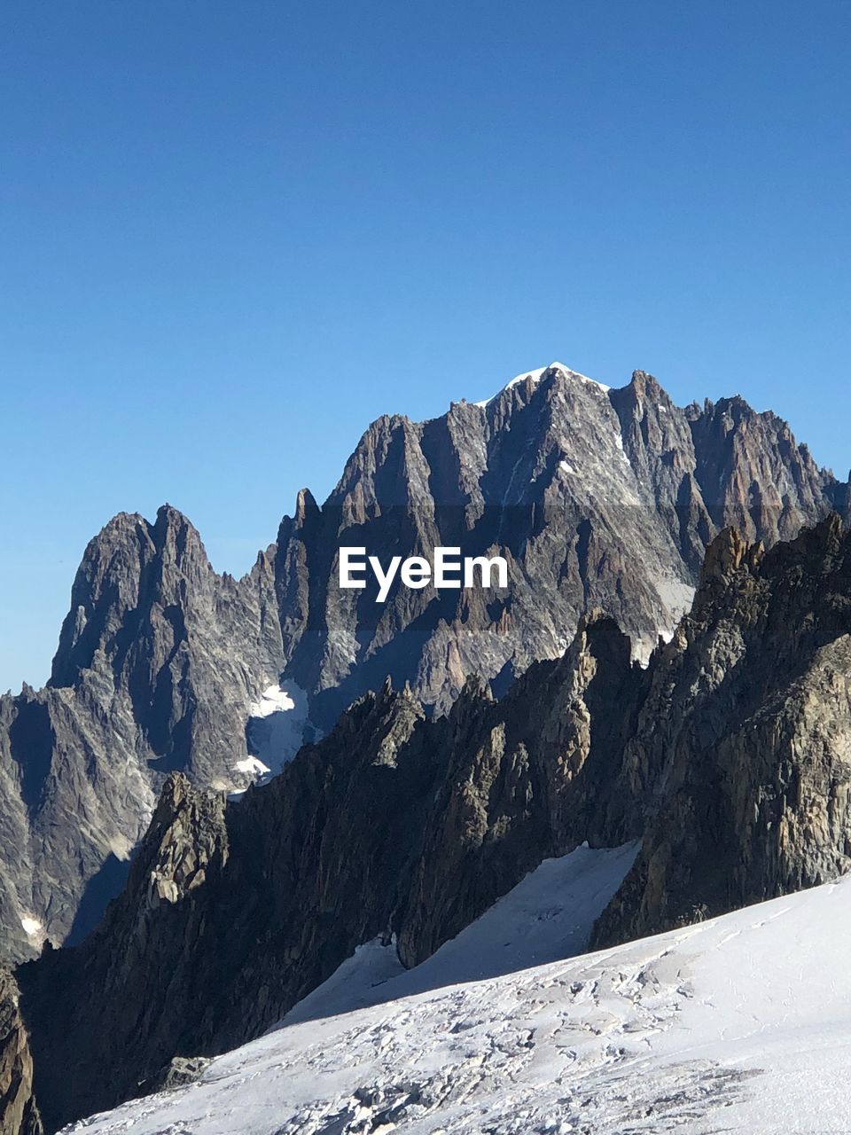 Scenic view of snowcapped mountains against clear blue sky