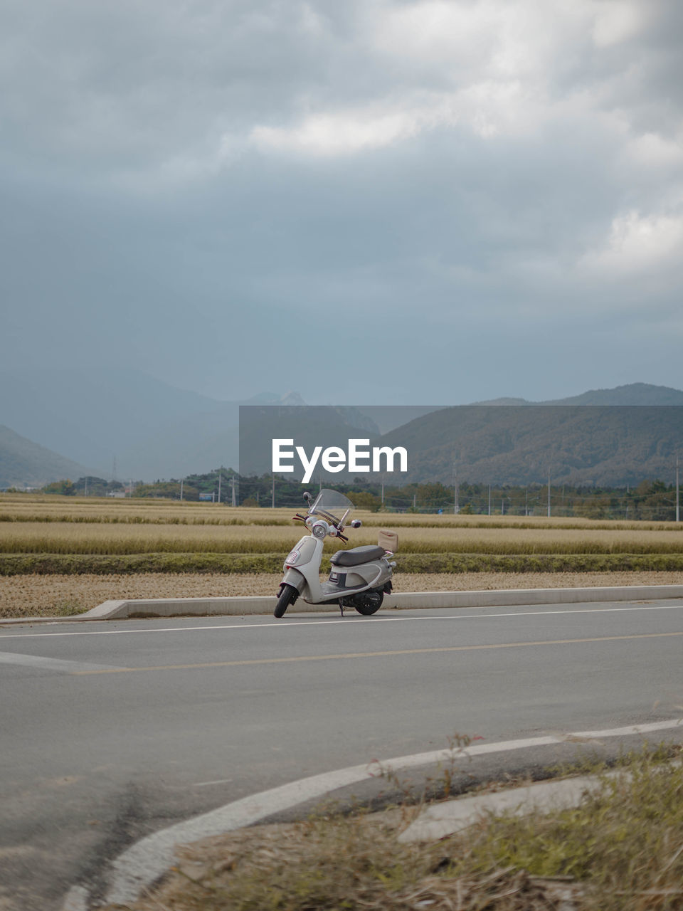 Man riding motorcycle on road against sky