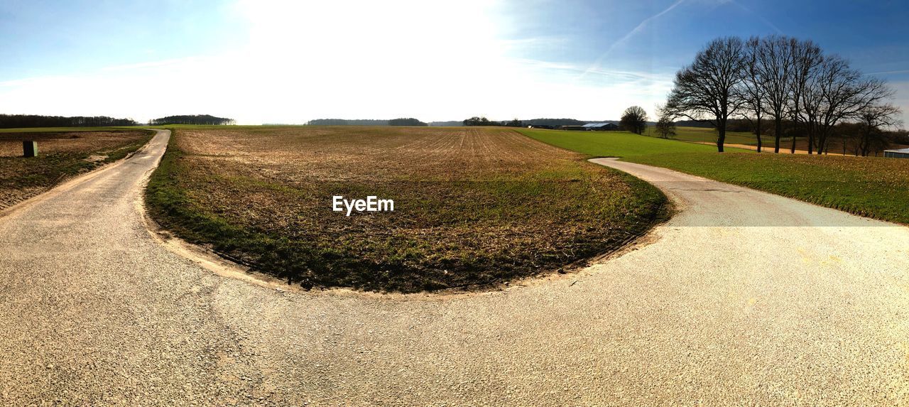PANORAMIC VIEW OF ROAD AMIDST FIELD