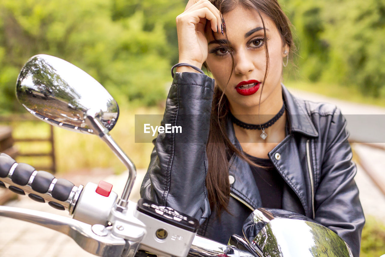 Portrait of beautiful woman siting on motorcycle