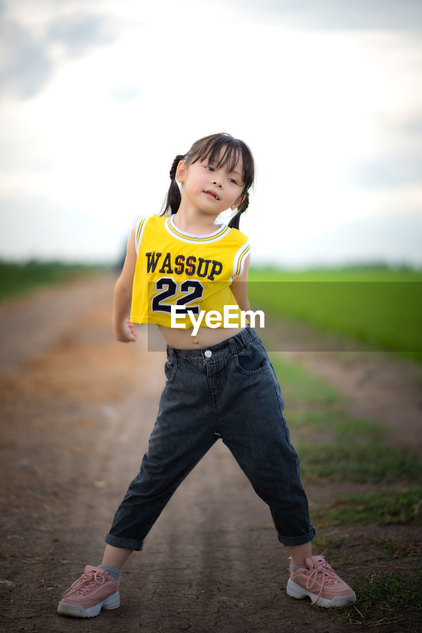 CUTE GIRL STANDING ON FIELD