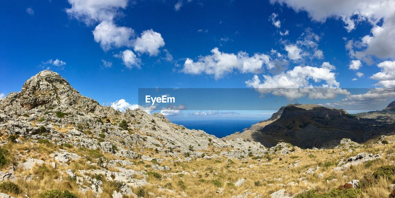 Scenic view of mountains against blue sky