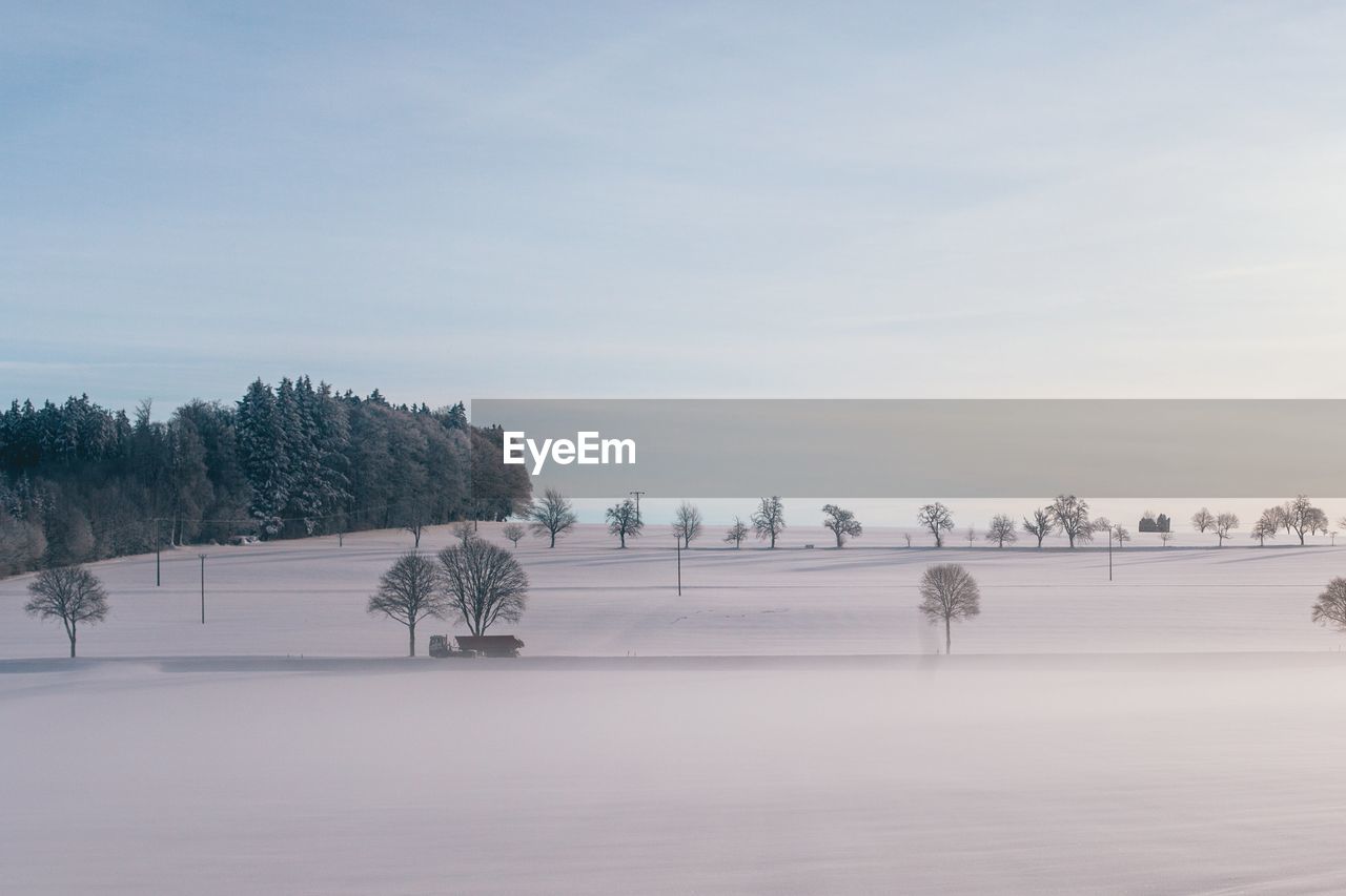 Scenic view of snow covered field against sky