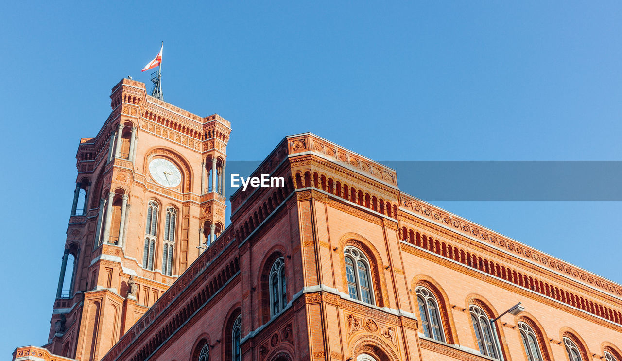 Low angle view of berlin town hall against clear sky on sunny day