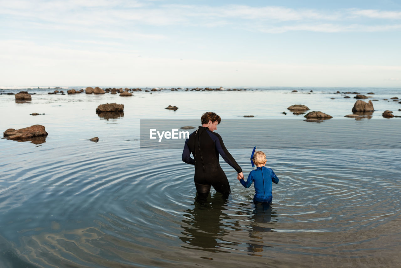 Father and young son preparing to snorkel