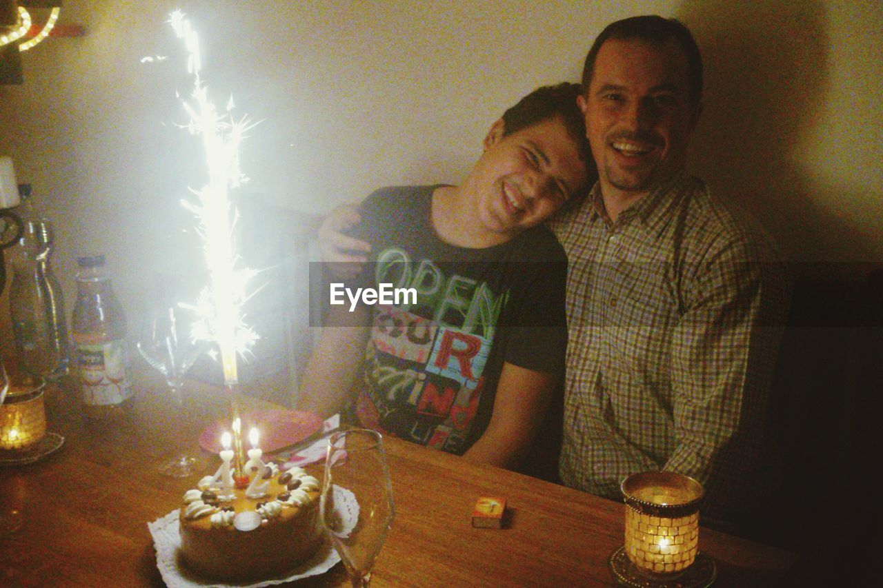 Portrait of happy father with son celebrating birthday in restaurant