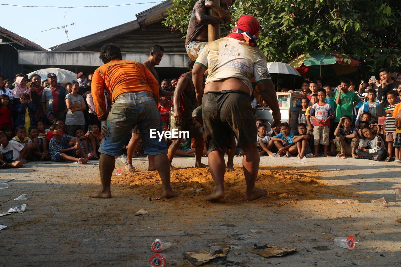 REAR VIEW OF PEOPLE ON STREET IN CITY