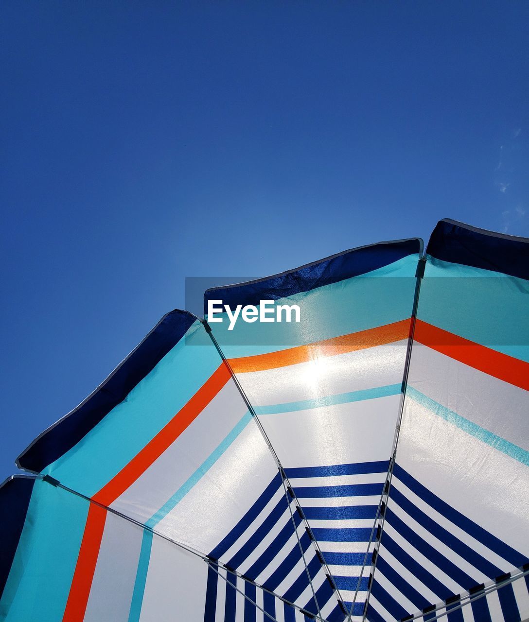 Close-up of parasol against clear blue sky