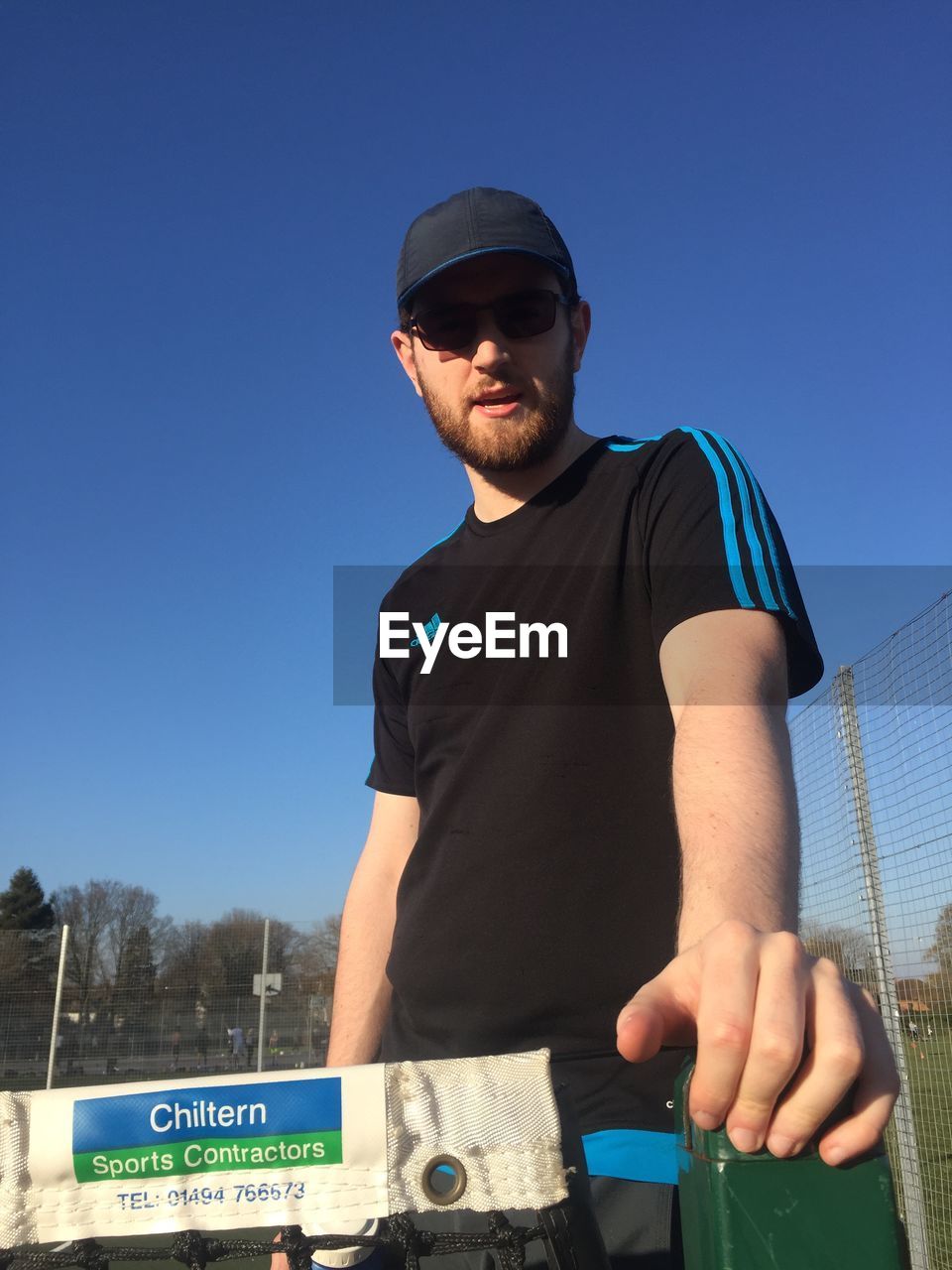 MAN STANDING AGAINST BLUE SKY