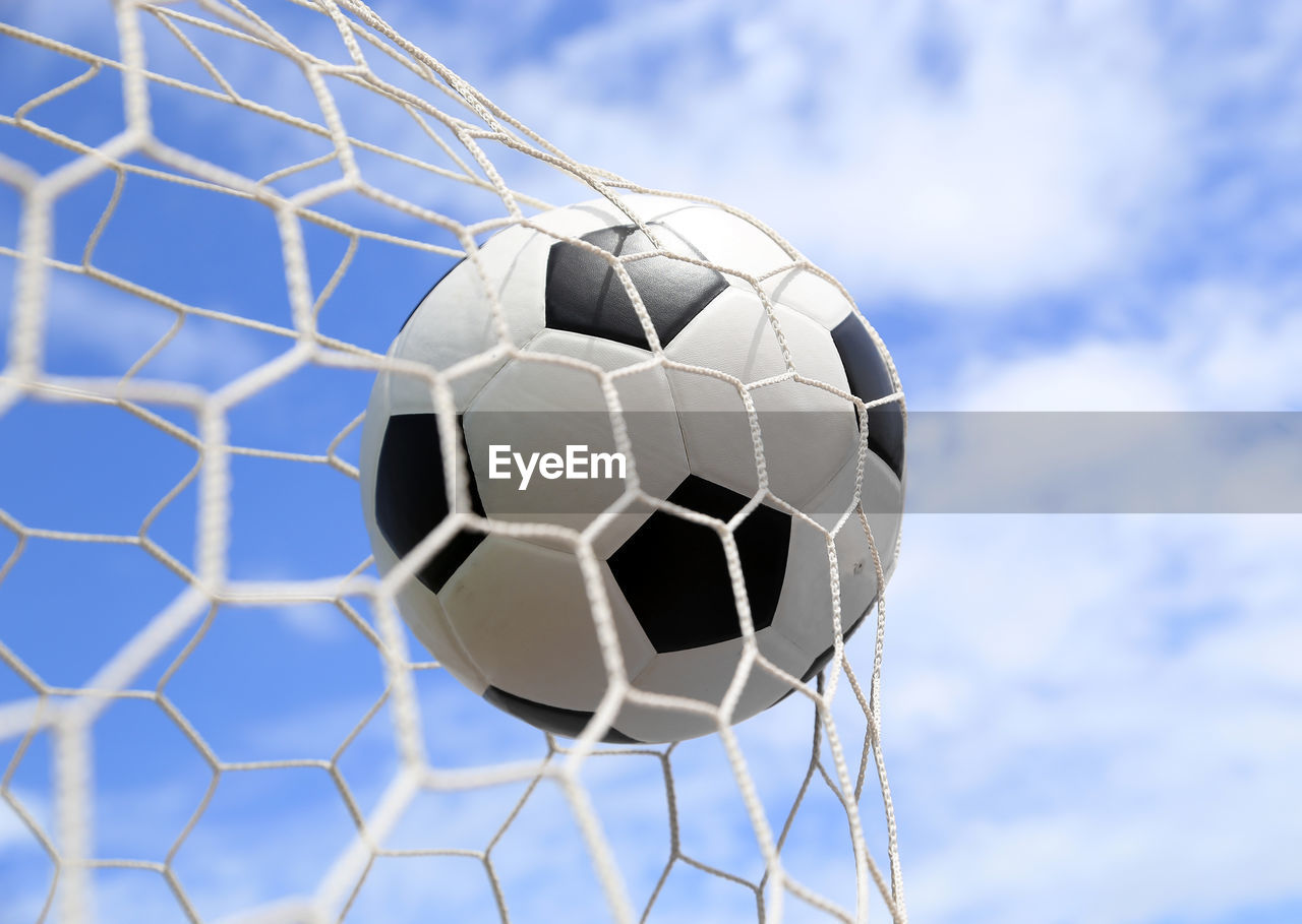 Soccer ball hitting in goal post against blue sky