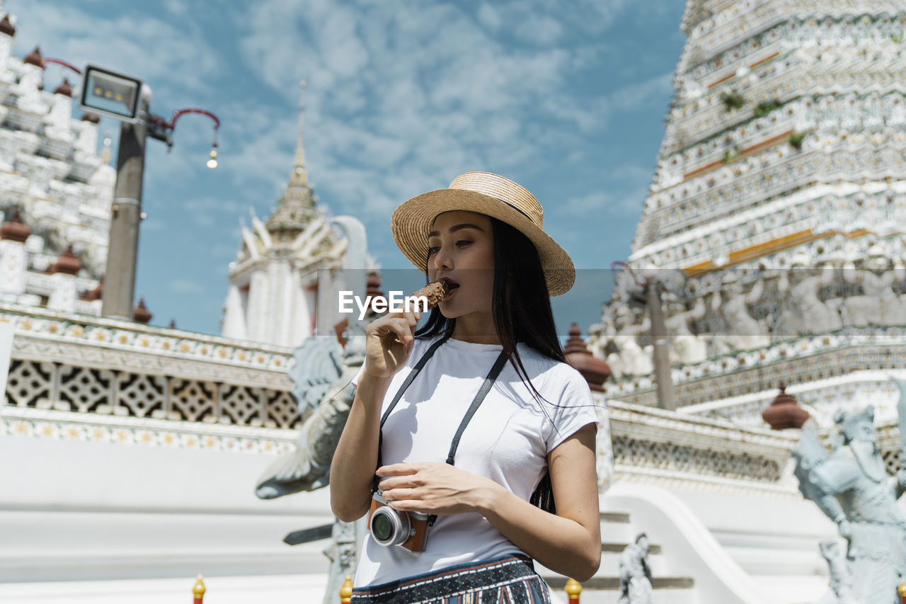 Woman eating ice cream against temple