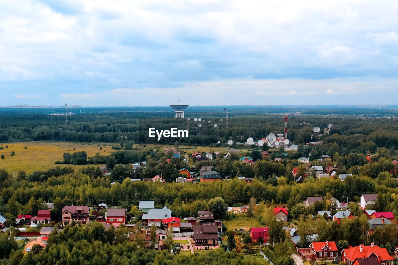 HIGH ANGLE VIEW OF BUILDINGS AND TREES AGAINST SKY