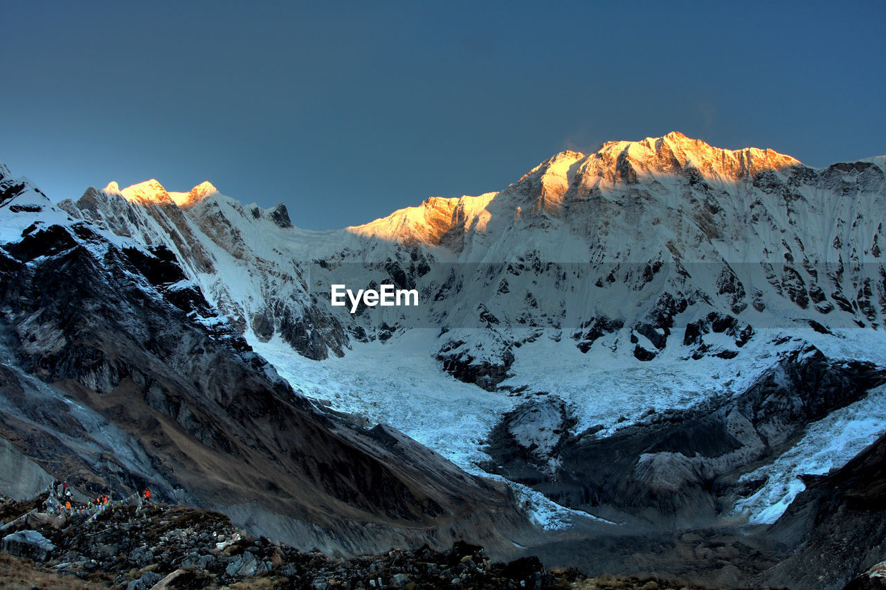 Scenic view of snowcapped mountains against clear sky