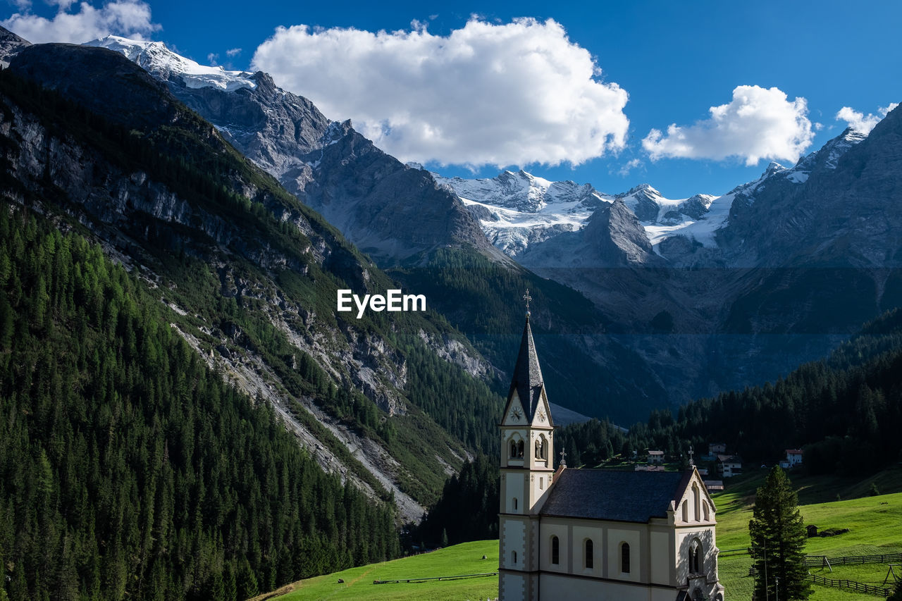 High angle view of church by mountains against sky