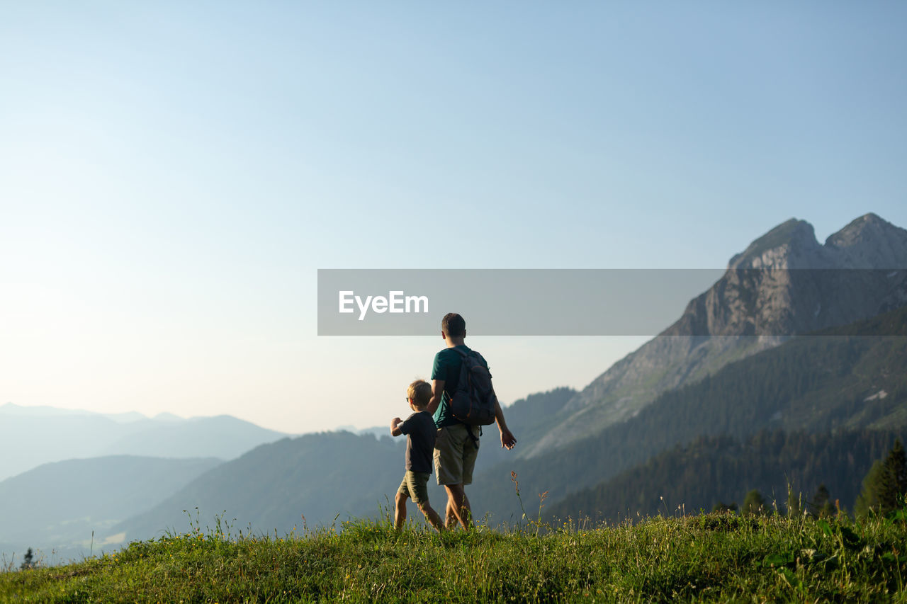 Father and son hiking in mountains. summer holidays concept.