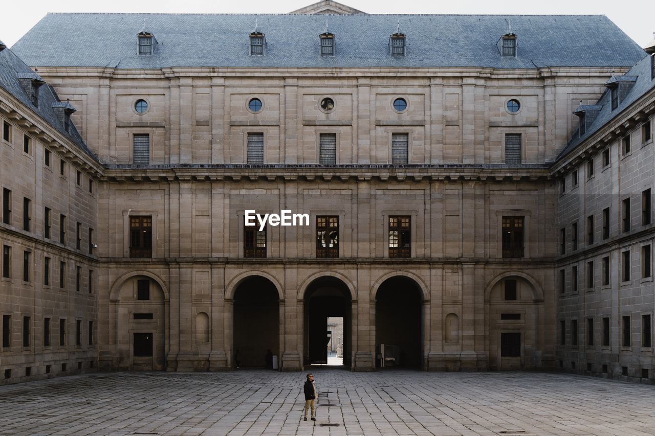 WOMAN STANDING BY BUILDING