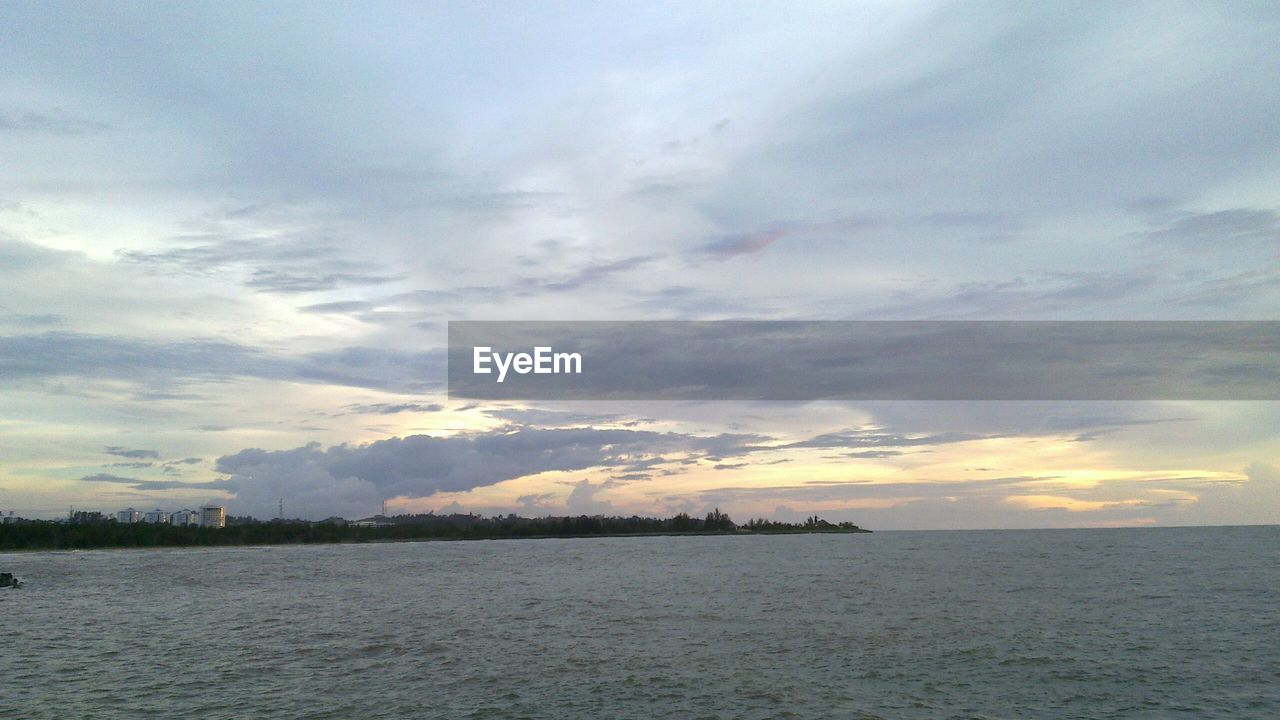 VIEW OF CALM SEA AT SUNSET