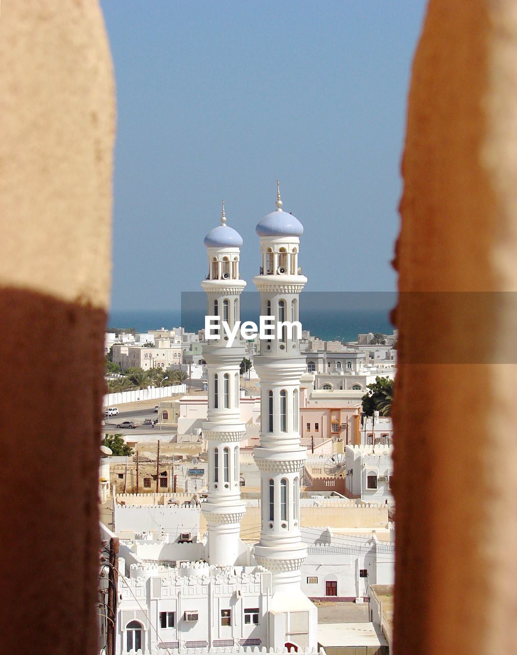 Buildings and mosque in city against sky