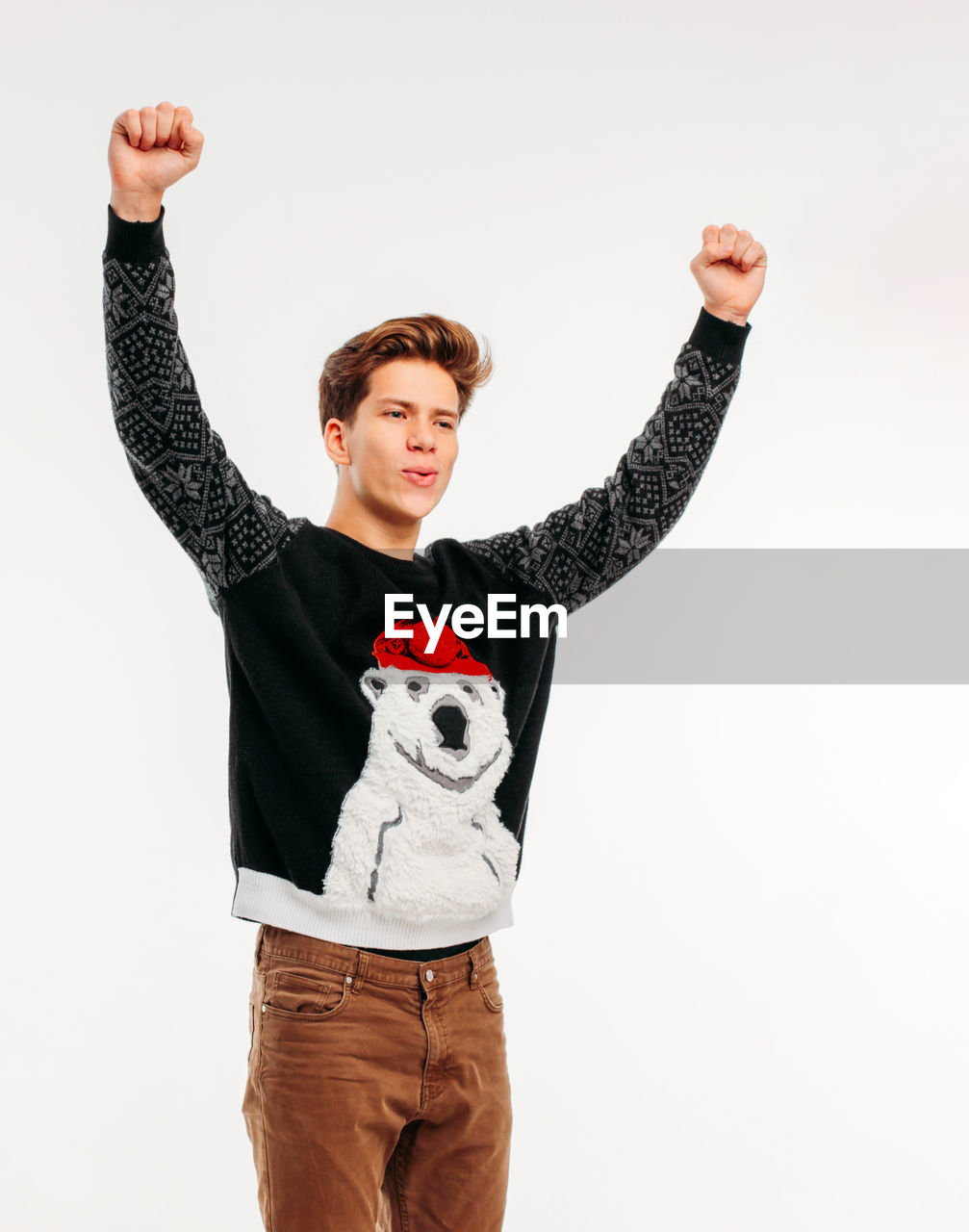 Young man clenching fists against white background