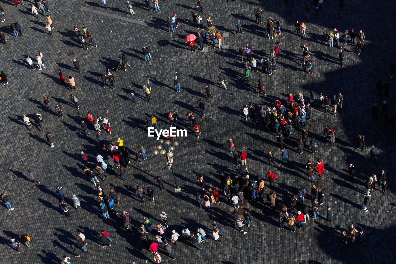 High angle view of people and long shadows on street