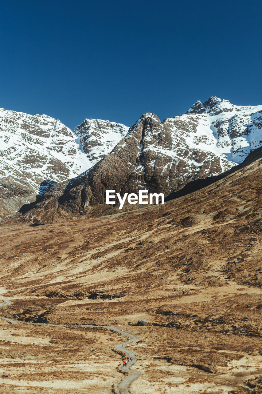 SNOWCAPPED MOUNTAINS AGAINST CLEAR BLUE SKY