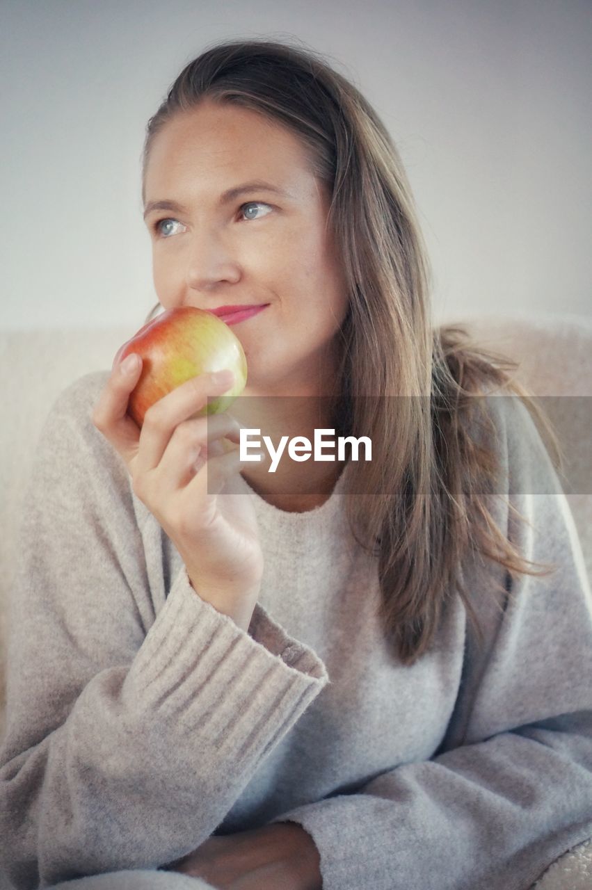 portrait of young woman holding fruit