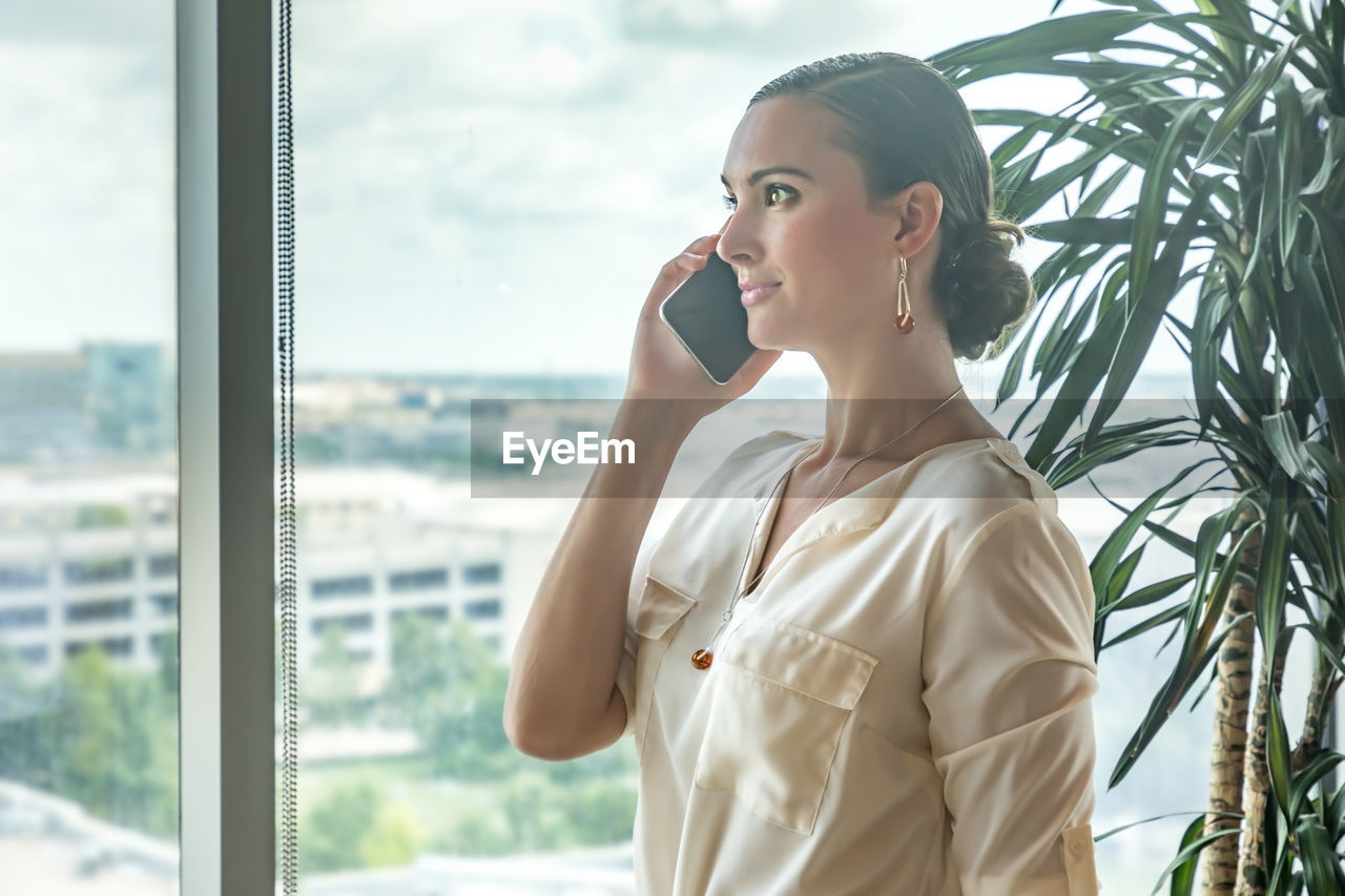 Woman looking away while talking on smart phone