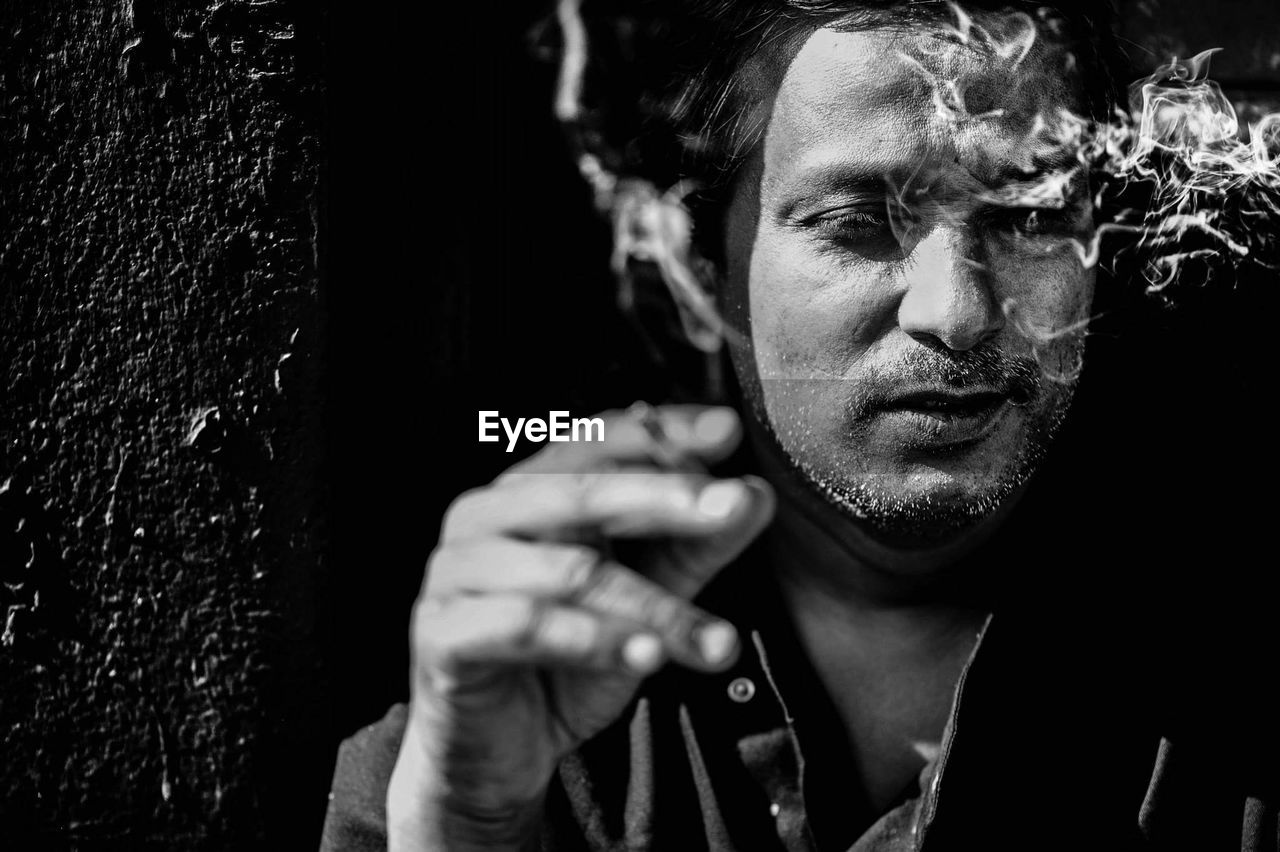 CLOSE-UP PORTRAIT OF YOUNG MAN SMOKING