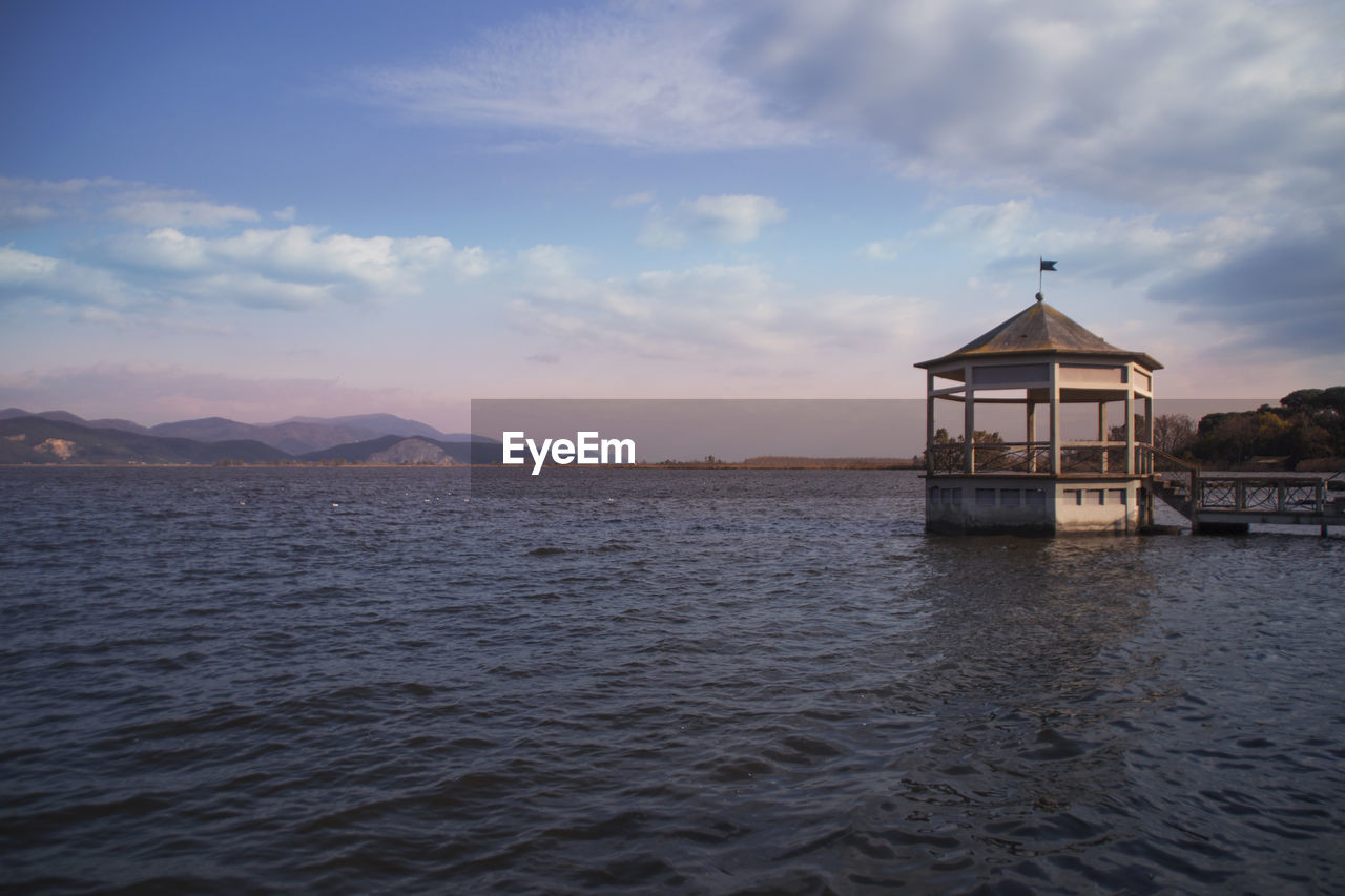 Scenic view of calm sea against cloudy sky