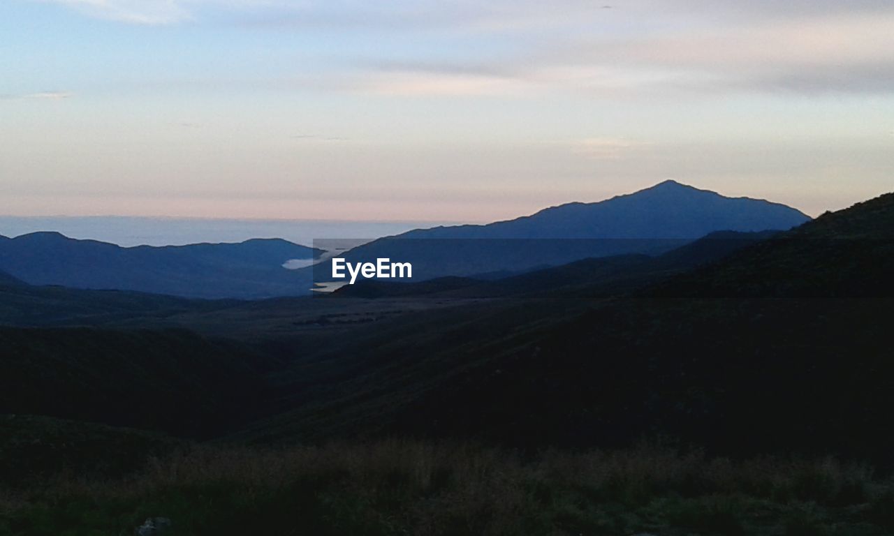 VIEW OF MOUNTAIN RANGE AGAINST CLOUDY SKY