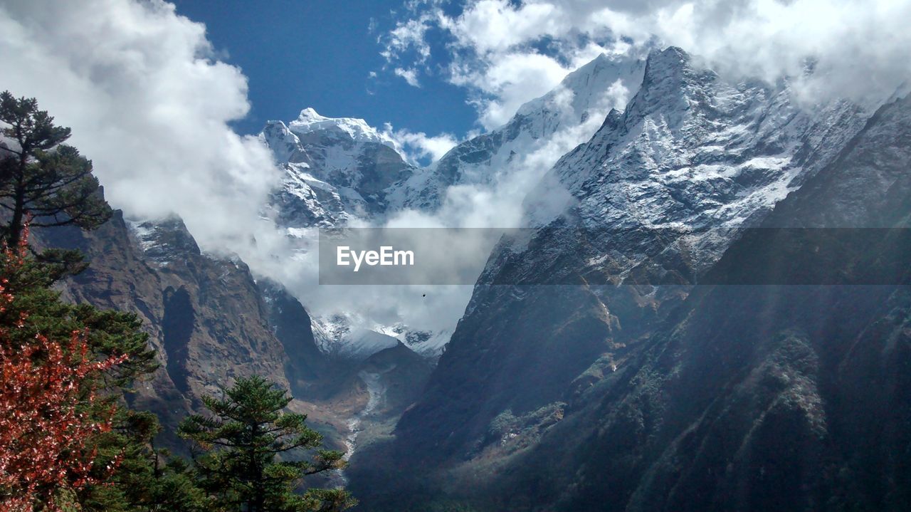 SCENIC VIEW OF SNOWCAPPED MOUNTAINS AGAINST CLOUDY SKY