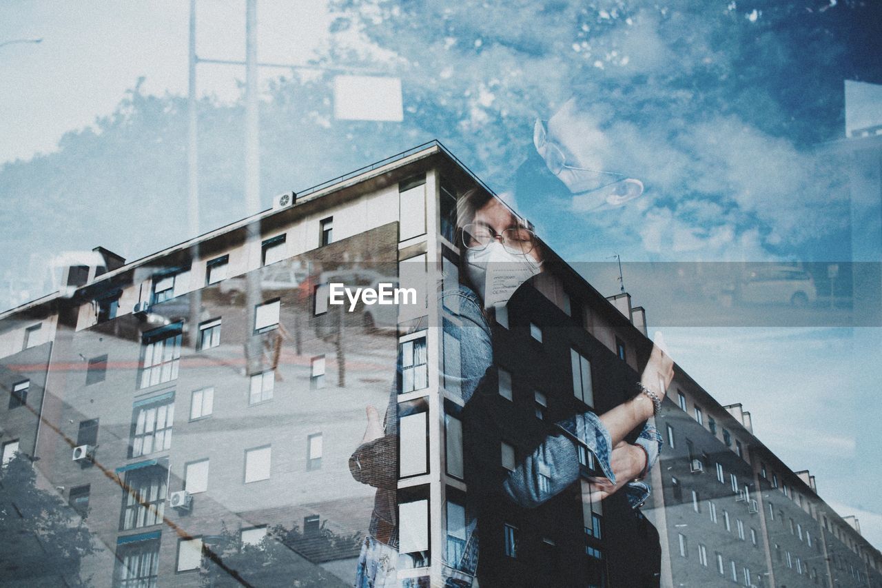 DIGITAL COMPOSITE IMAGE OF YOUNG WOMAN LOOKING THROUGH WINDOW