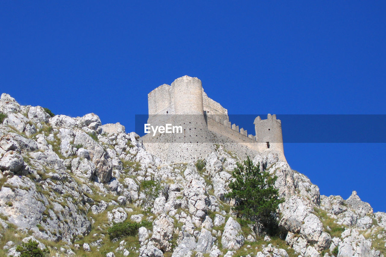 Low angle view of fort against clear blue sky