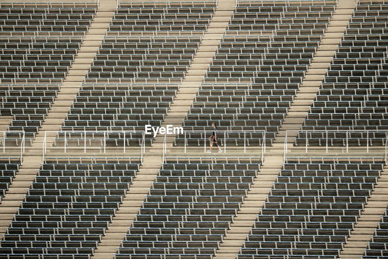 Full frame shot of empty stadium seating with one person