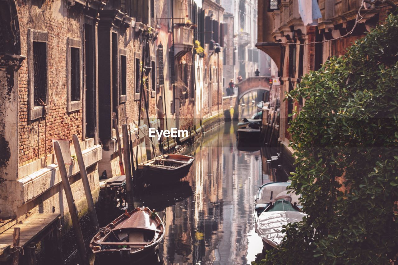 Boats in canal amidst buildings