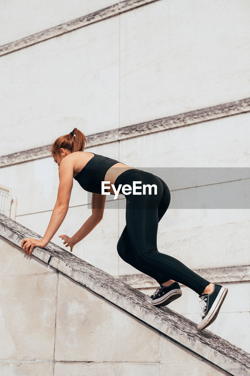 Low section of woman exercising on bridge