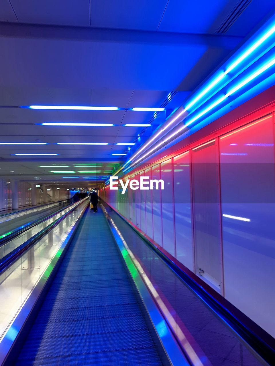 Illuminated moving walkway in building