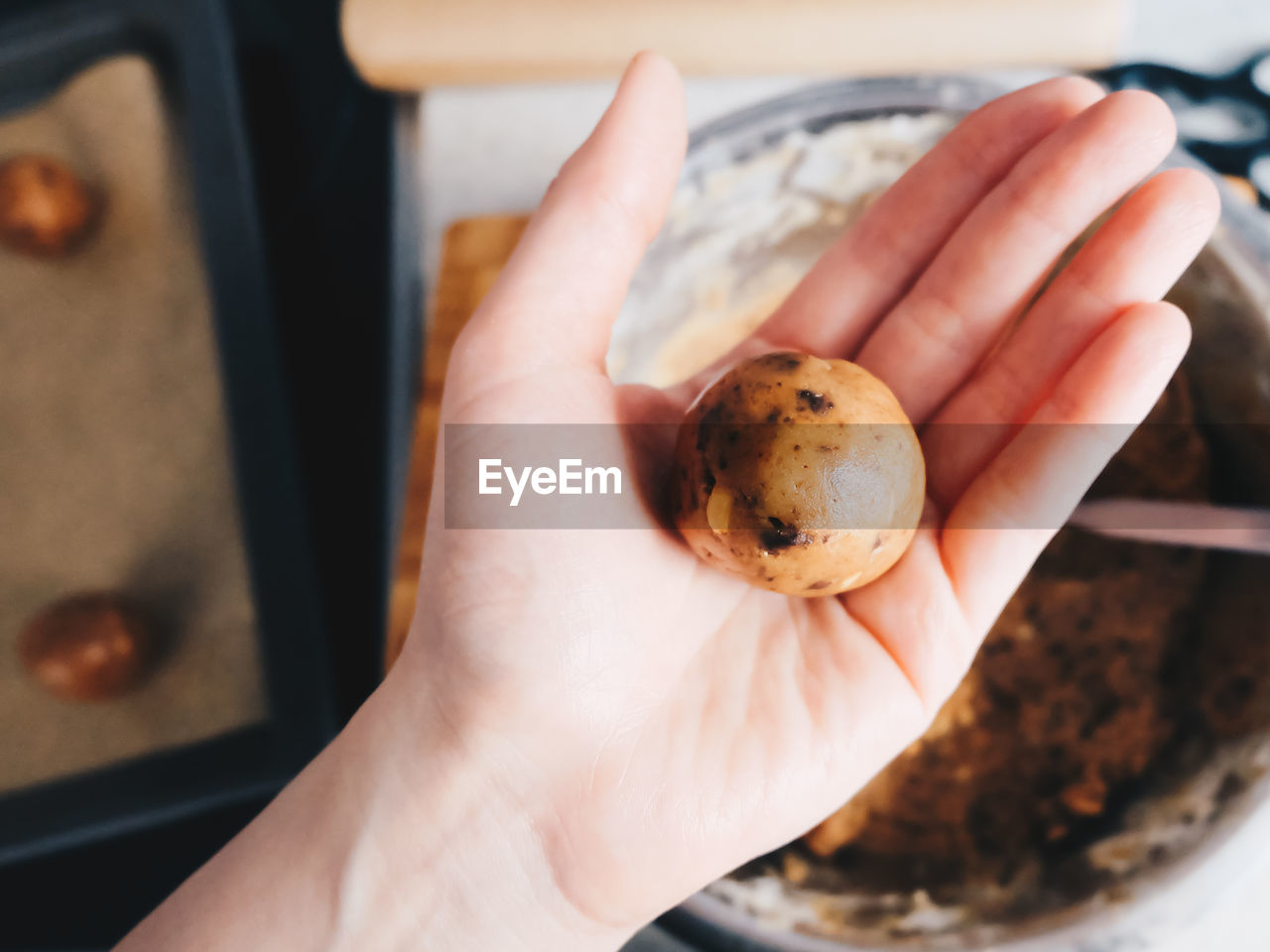 Close-up of human hand holding raw cookie 