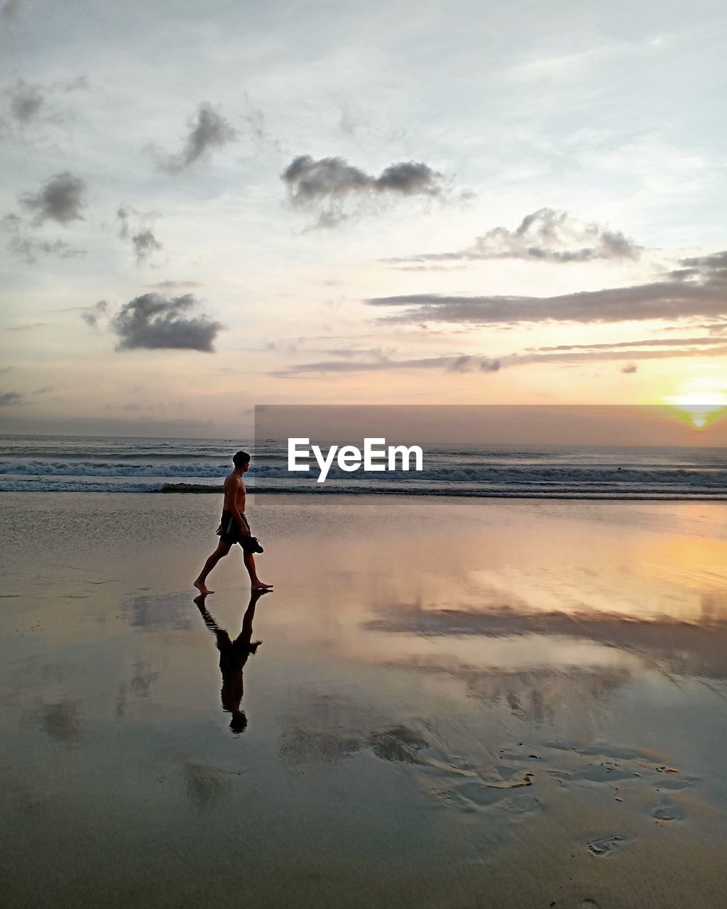 water, sky, sea, sunset, beach, one person, land, reflection, full length, nature, cloud, ocean, beauty in nature, adult, silhouette, horizon, horizon over water, wave, shore, scenics - nature, body of water, tranquility, coast, lifestyles, men, walking, leisure activity, sports, holiday, sand, vacation, motion, environment, trip, sunlight, standing, outdoors, dusk, solitude, landscape, sun, tranquil scene, travel, person, idyllic, relaxation