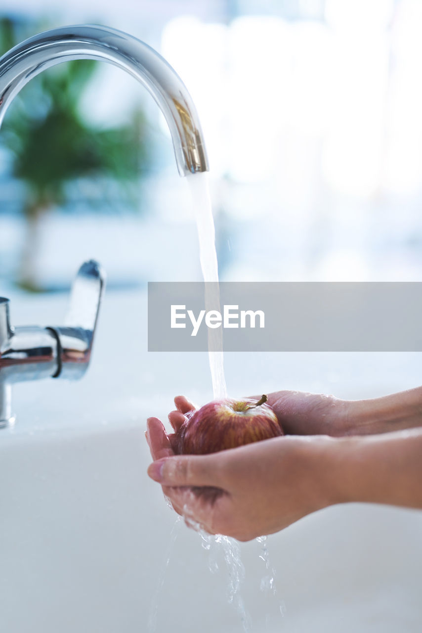 cropped hand of man washing hands