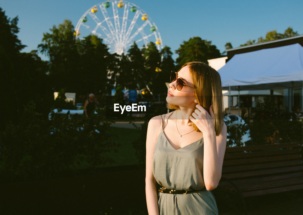 Young woman wearing sunglasses while standing outdoors